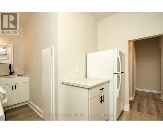 A white refrigerator in a kitchen with wooden cabinets.