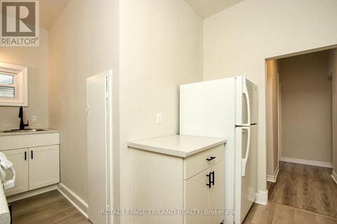 A white refrigerator in a kitchen with wooden cabinets.