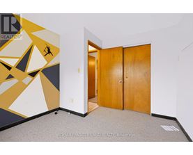 A room with a yellow and black geometric mural and a wooden door.