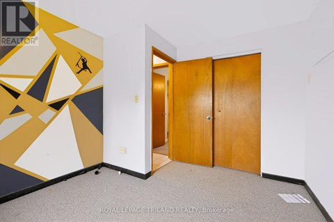 A room with a yellow and black geometric mural and a wooden door.