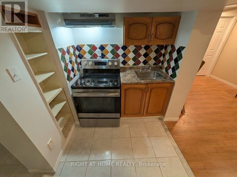 A kitchen with a stove top oven and a sink.