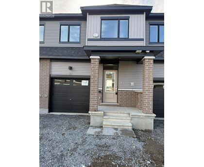 A modern house with a grey and black exterior and a glass door.