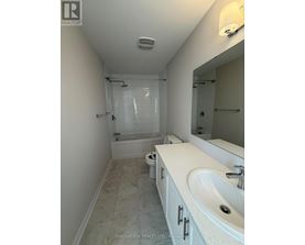 A white bathroom with a sink, toilet and shower.