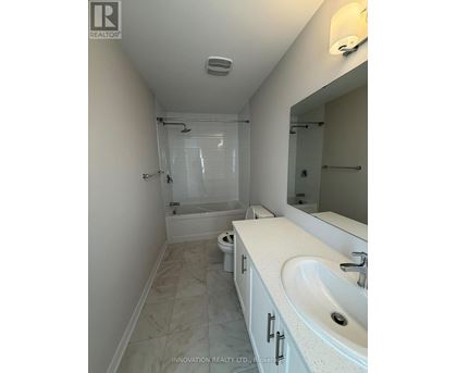 A white bathroom with a sink, toilet and shower.