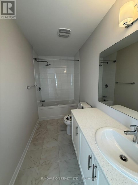 A white bathroom with a sink, toilet and shower.