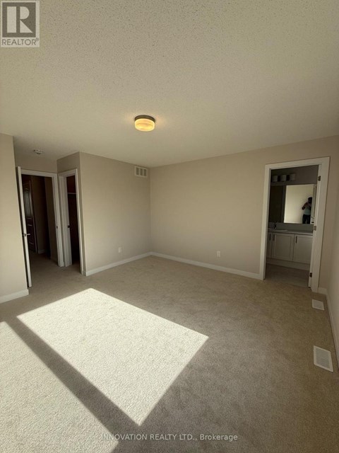 A spacious room with a carpeted floor and a ceiling light.