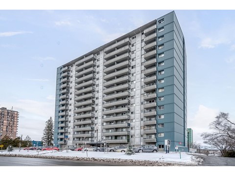 A tall residential building with many windows and balconies.