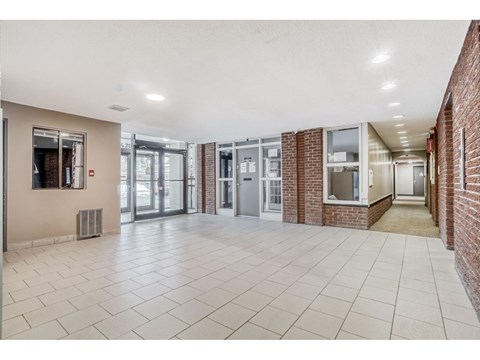 A hallway with tiled floors and brick walls.