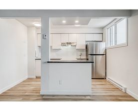 A modern kitchen with white cabinets and stainless steel appliances.