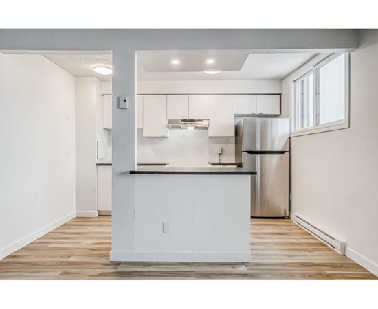 A modern kitchen with white cabinets and stainless steel appliances.