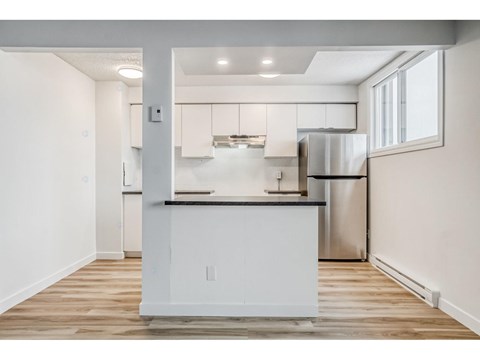A modern kitchen with white cabinets and stainless steel appliances.