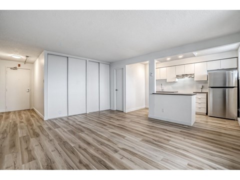 A kitchen with white cabinets and a wooden floor.