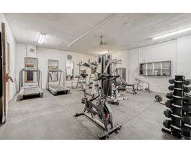 A gym with a variety of equipment including treadmills, weights, and exercise machines.