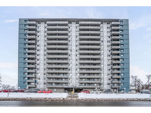 A large grey and blue building with multiple balconies.