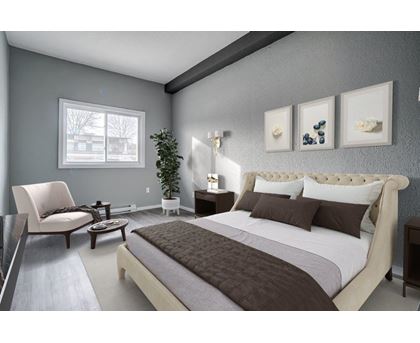A bedroom with a large bed and a chair.