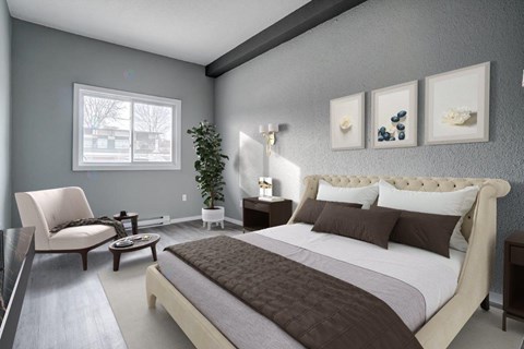 A bedroom with a large bed and a chair.