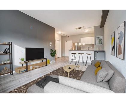 A modern living room with a grey sofa and a wooden coffee table.
