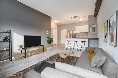 A modern living room with a grey sofa and a wooden coffee table.