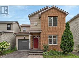 A two-story brick house with a red door and a garage.