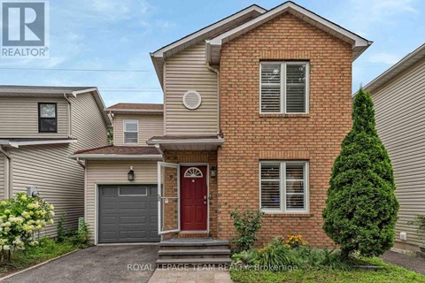 A two-story brick house with a red door and a garage.