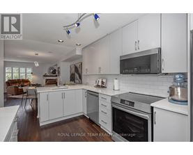 A modern kitchen with white cabinets and stainless steel appliances.