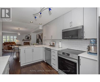A modern kitchen with white cabinets and stainless steel appliances.