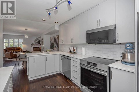 A modern kitchen with white cabinets and stainless steel appliances.