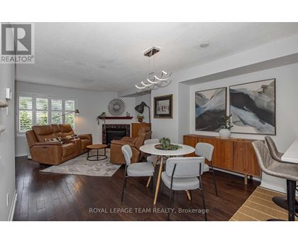 A living room with a fireplace and a painting on the wall.
