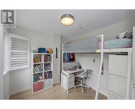 A white bedroom with a bunk bed and a desk.