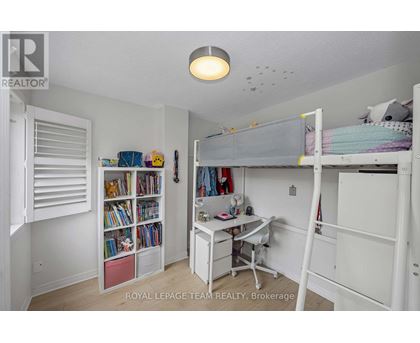 A white bedroom with a bunk bed and a desk.