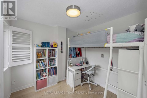 A white bedroom with a bunk bed and a desk.