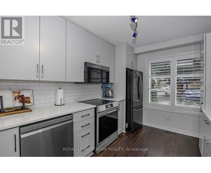 A kitchen with white cabinets and a stainless steel dishwasher.
