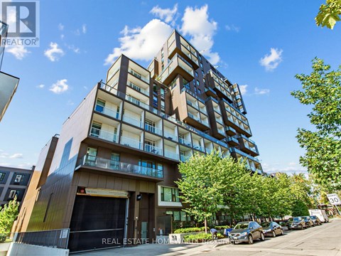 A modern multi-story building with a glass facade and balconies.
