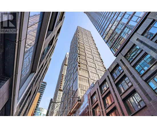 A tall building stands in the middle of a cluster of other buildings.