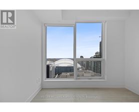 A room with a large window showing a cityscape.