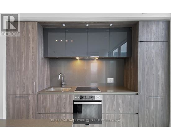 A modern kitchen with a stainless steel oven and wooden cabinets.