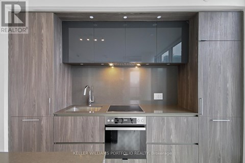 A modern kitchen with a stainless steel oven and wooden cabinets.