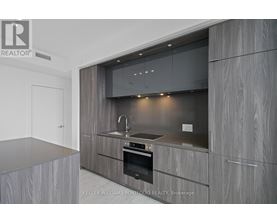 A modern kitchen with a stainless steel oven and wooden cabinets.