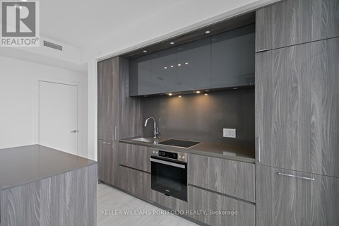 A modern kitchen with a stainless steel oven and wooden cabinets.
