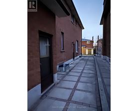 A narrow alleyway between two red brick buildings.