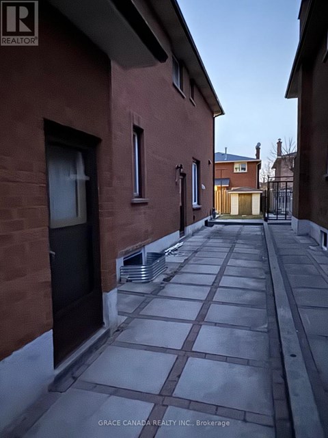 A narrow alleyway between two red brick buildings.