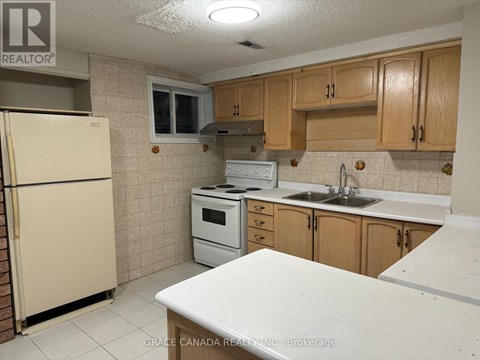 A kitchen with a white counter top and wooden cabinets.