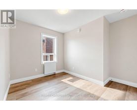 A room with a window and a radiator on the floor.