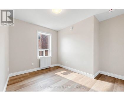 A room with a window and a radiator on the floor.