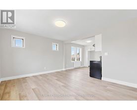A spacious room with wooden flooring and a flat screen TV.