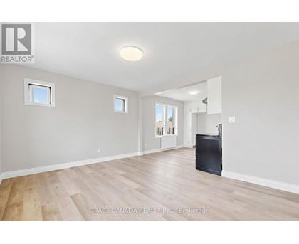 A spacious room with wooden flooring and a flat screen TV.