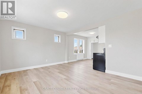 A spacious room with wooden flooring and a flat screen TV.