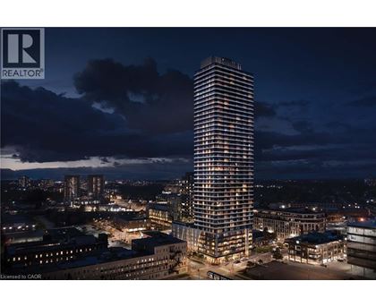 A tall, illuminated building stands in the center of a cityscape at night.