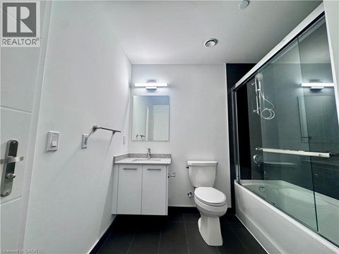 A white bathroom with a toilet, sink, and shower.