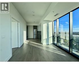 A spacious room with wooden floors and large windows.